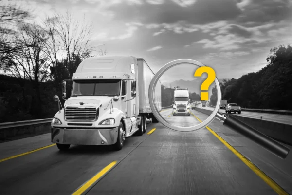 2 trucks on the road with one under a magnifying glass and a question mark